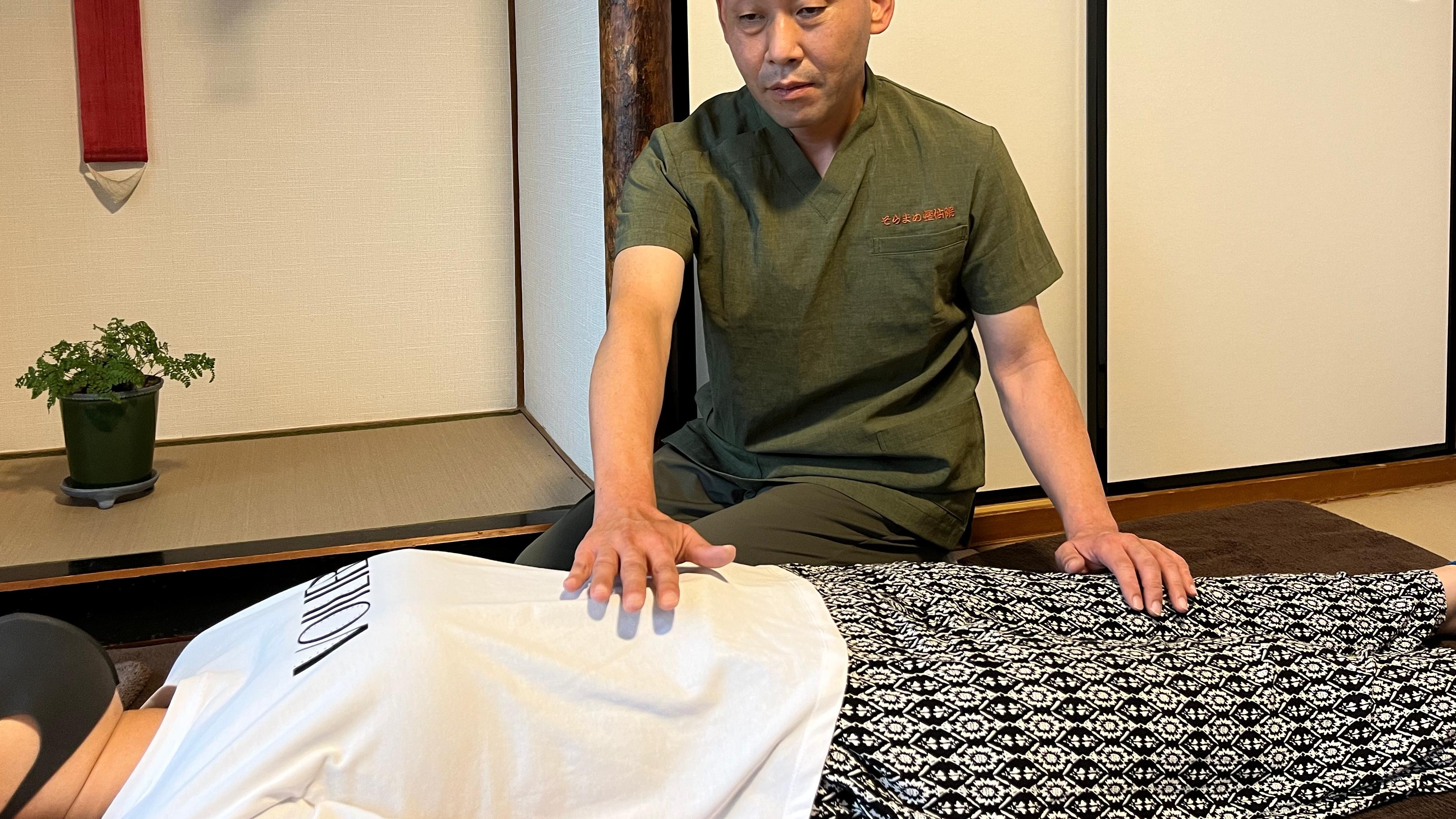 Usui Reiki practitioner placing hands for energy healing during a private Reiki session in Japan